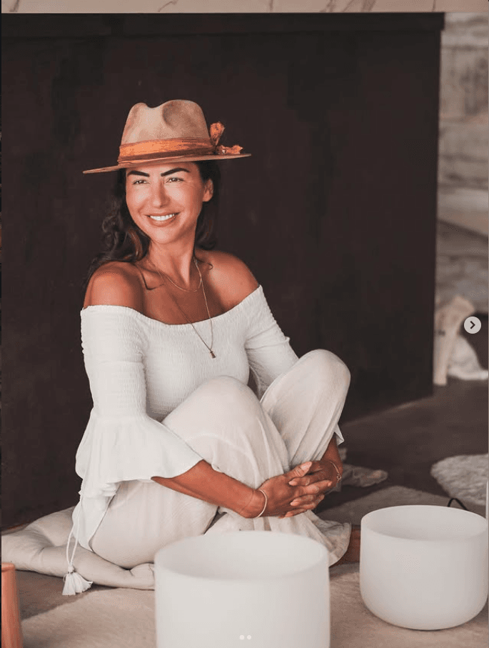 Tanya Ryder seated in white with crystal singing bowls